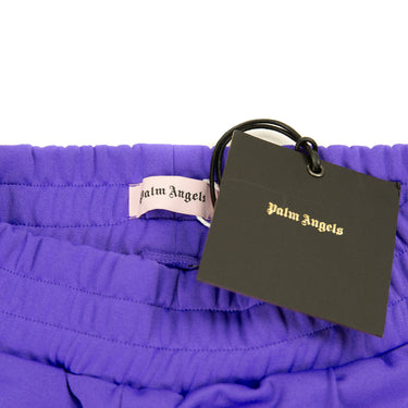 The inside label and tag of the Palm Angels Purple Sweatpants.
