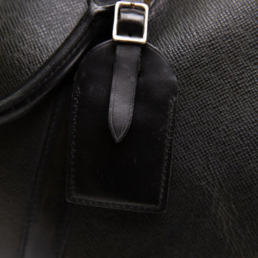The buckle of the Louis Vuitton Black Duffel Bag.