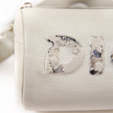 A detailed close-up of the Dior x Daniel Arsham White Leather Roller Bag, highlighting its grained calfskin material.