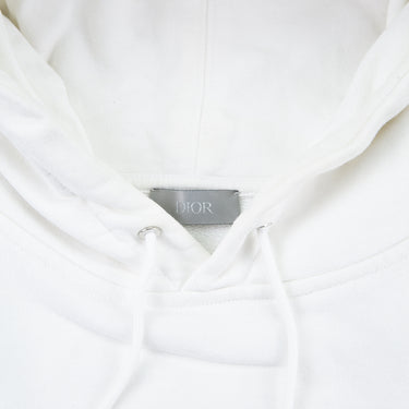 The inside label of the Dior x Kaws Bee Embroidered White Hoodie.