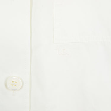 The buttons on a Burberry white button-up shirt.
