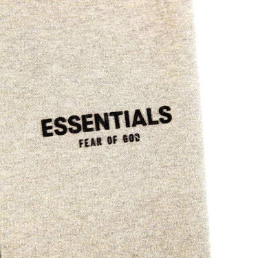 The logo of the Fear Of God ESSENTIALS Light Oatmeal Sweatpants M.