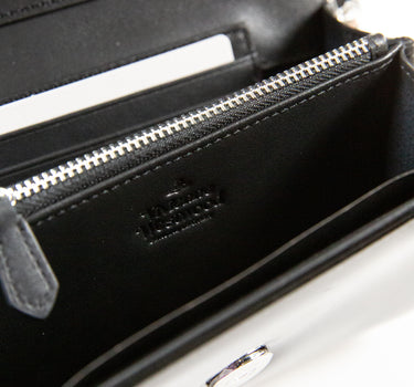 Inside view showing the logo of a Vivienne Westwood Patent Leather Crossbody Bag in black.