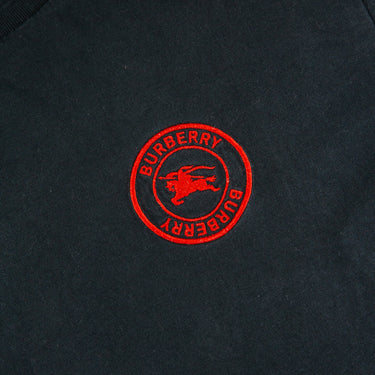 The logo of the Burberry Red Logo Black T Shirt.