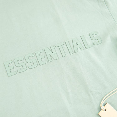 The logo of the Fear Of God ESSENTIALS Sycamore T Shirt.
