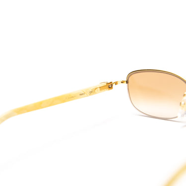 The lens of the Cartier 22ct Gold Plated Diamanté Ivory Acetate Rimless Sunglasses.