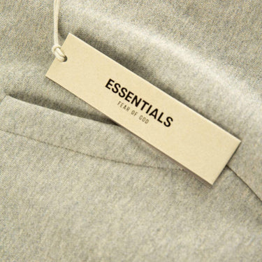 The tags of the Fear Of God ESSENTIALS Dark Oatmeal Hoodie L.