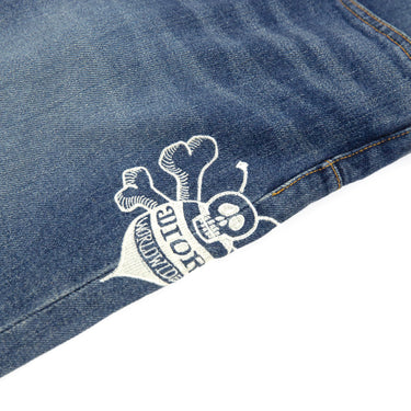 A detailed mid shot of the logo on the Dior x Stussy Bee Embroidered Jeans.
