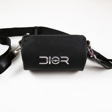 The front logo of the Dior x Sorayama Black Roller Bag, a symbol of luxury and partnership.
