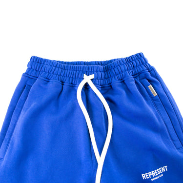 The front of the Represent Owners Club Blue Sweatpants.