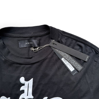 The collar of the Amiri Wes Lang Solar Kings Black T Shirt.