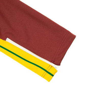 The leg of the Palm Angels Burgundy & Yellow Sweatpants.