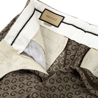 The inside label of Gucci G Print Trousers, Brown in color