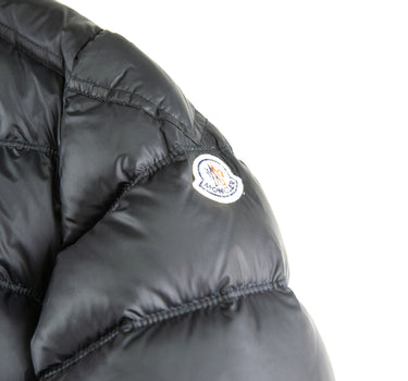 The logo of the Moncler Gaston Black Puffer Jacket.