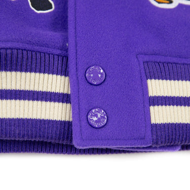 The band of a Louis Vuitton Multi-Patches Mixed Leather Varsity Jacket in purple with white sleeves and orange patches.