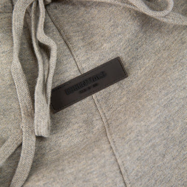 The front label of the Fear Of God ESSENTIALS Dark Oatmeal Sweatpants.