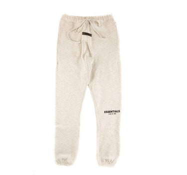 The front of the Fear Of God ESSENTIALS Light Oatmeal Sweatpants.