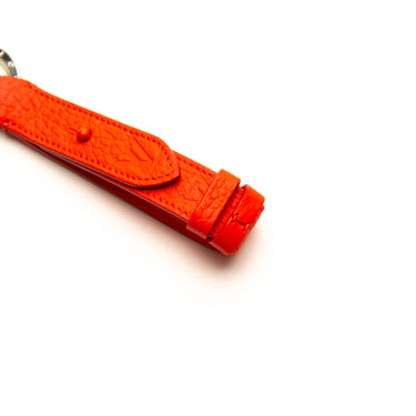 The logo of the Louis Vuitton Red Harness Dragonne Bag Charm.