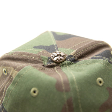 The logo of the Chrome Hearts CH Camo Trucker Hat.