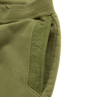 The pocket of the C.P. Company Diagonal Fleece Mixed Lens Khaki Sweatpants.