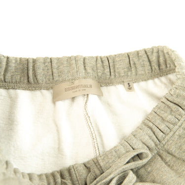 The inside label of the Fear Of God ESSENTIALS Dark Oatmeal Shorts.