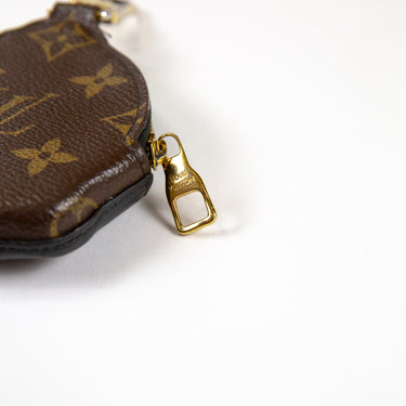Shows the zip of a Louis Vuitton x Nigo Duck Coin Holder in green, black, and yellow.