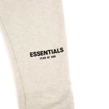 The leg of the Fear Of God ESSENTIALS Light Oatmeal Sweatpants.