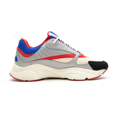 The left of the Dior Dior B22 Grey Red Blue Trainer.
