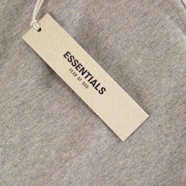 The tags of the Fear Of God ESSENTIALS Dark Oatmeal Sweatpants S.