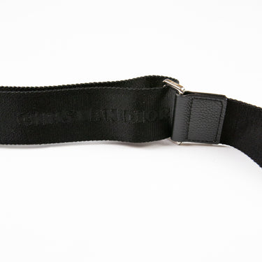 Displays the buckle of the Dior x Sorayama Black Roller Bag, detailing its intricate design.