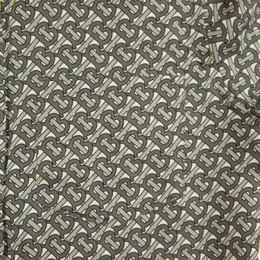 The monogram print of the Burberry TB Monogram Silk Shirt.