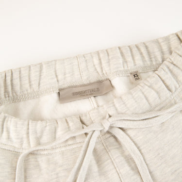 The waistband of the Fear Of God ESSENTIALS Light Oatmeal Sweatpants.